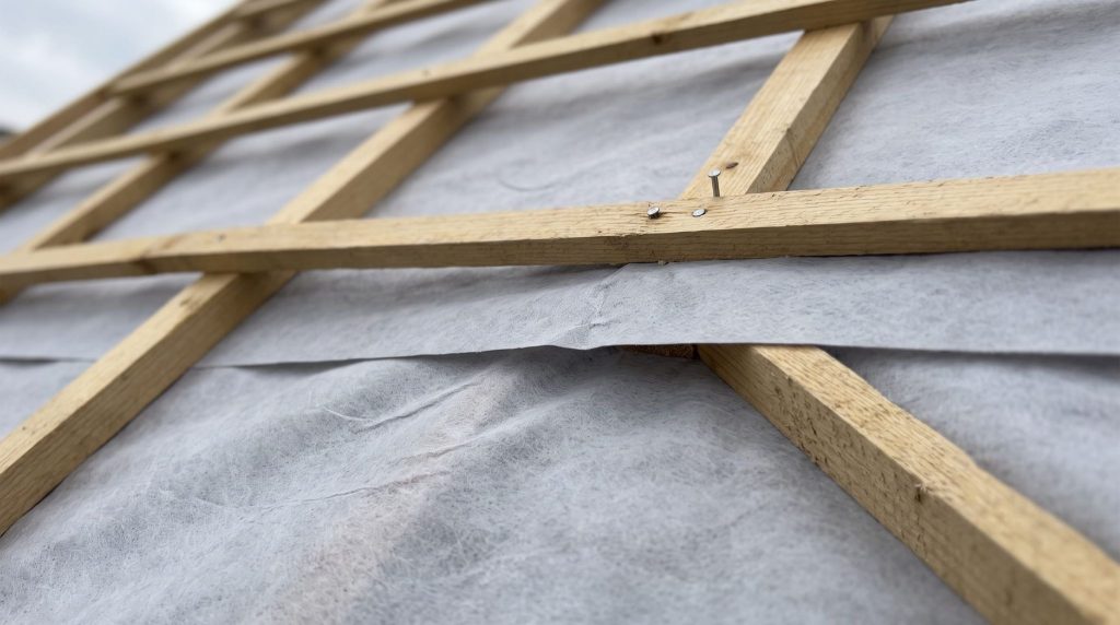 Close-up of a breather membrane overlapping across roof rafters before battens are fitted